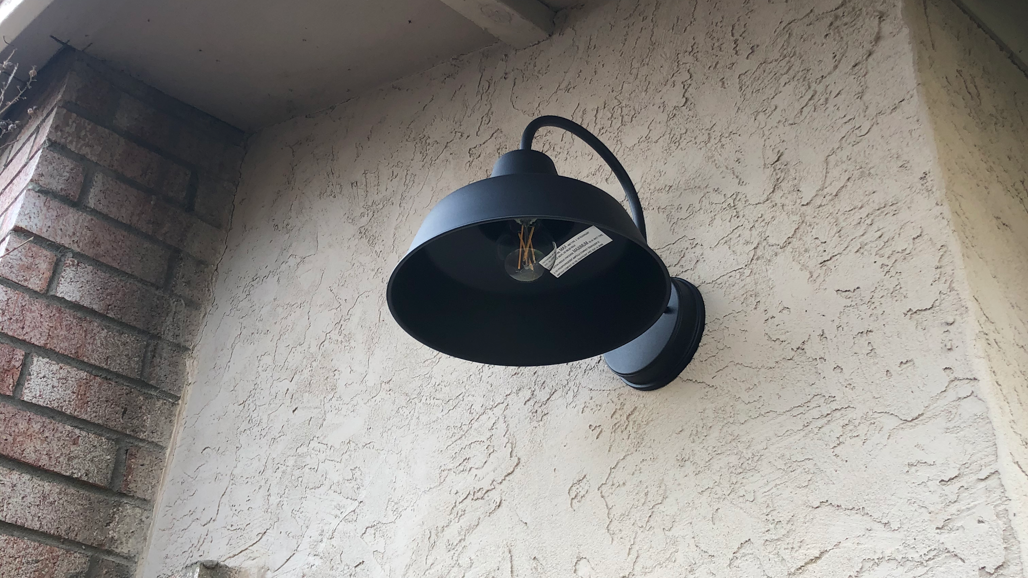 Black barn-style outdoor wall sconce installed by Nelson Electric